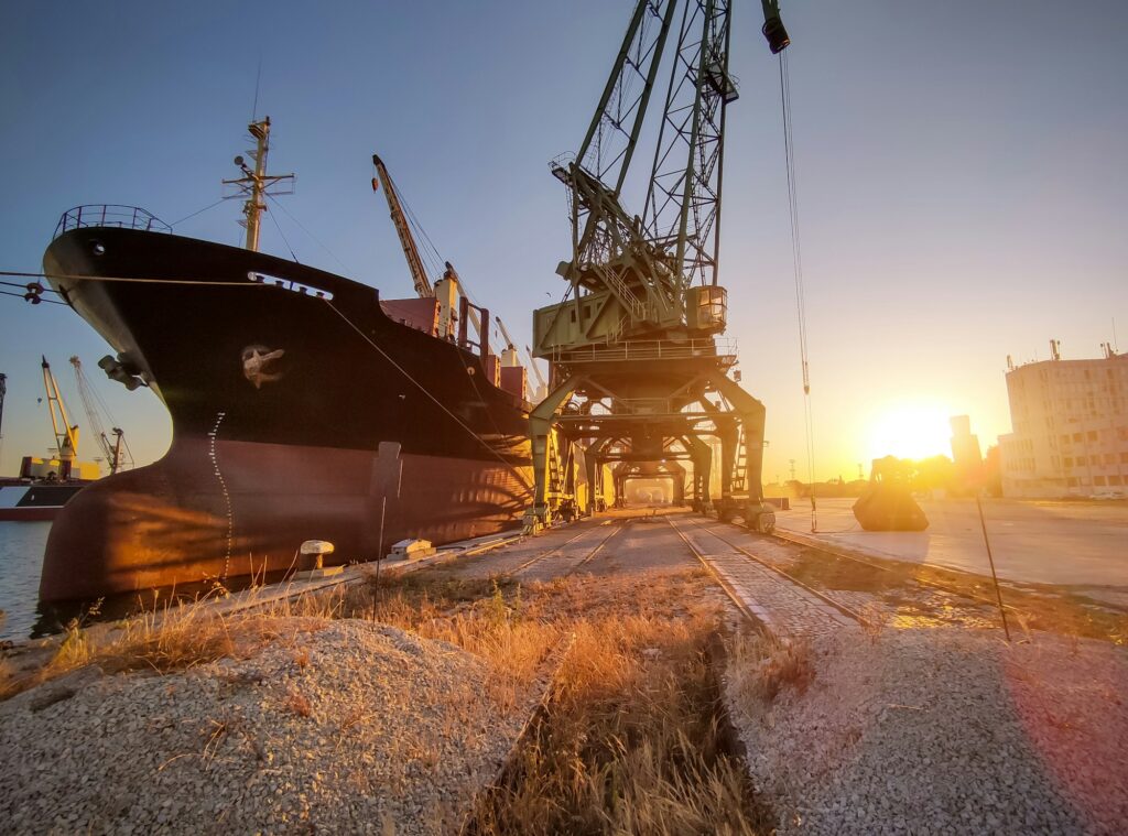 cargo ship bulk carrier is loaded with grain of wheat in port at sunset